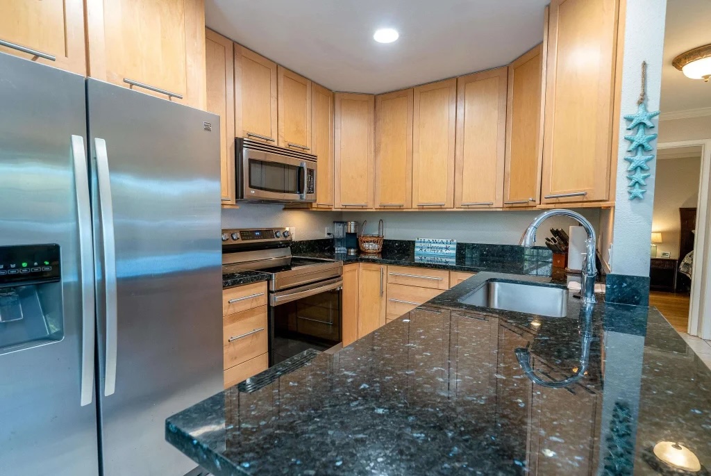 Updated kitchen at 140 Uwapo Rd 26-103 with granite countertops maple cabinets and stainless steel appliances