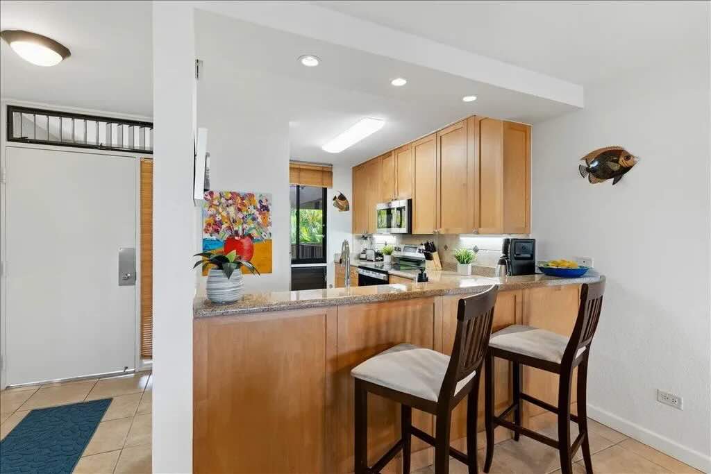 Bright living area with tile flooring inside Kamaole Sands 5-205 in Kihei