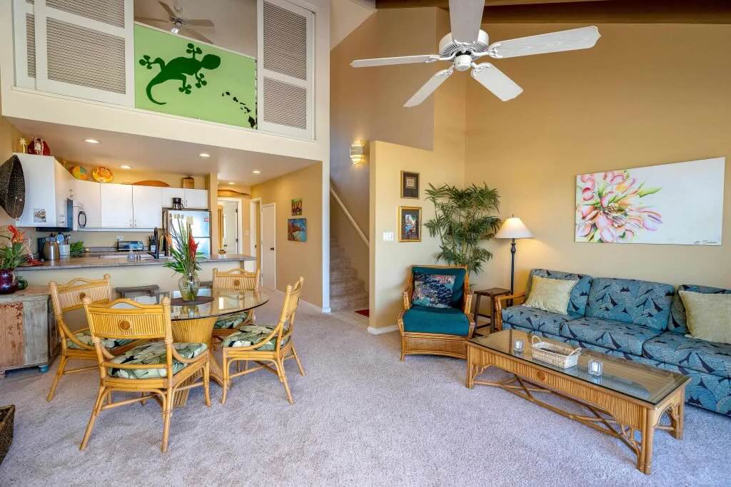 Furnished living room inside Maui Kamaole L204 with natural light and access to the ocean-view lanai