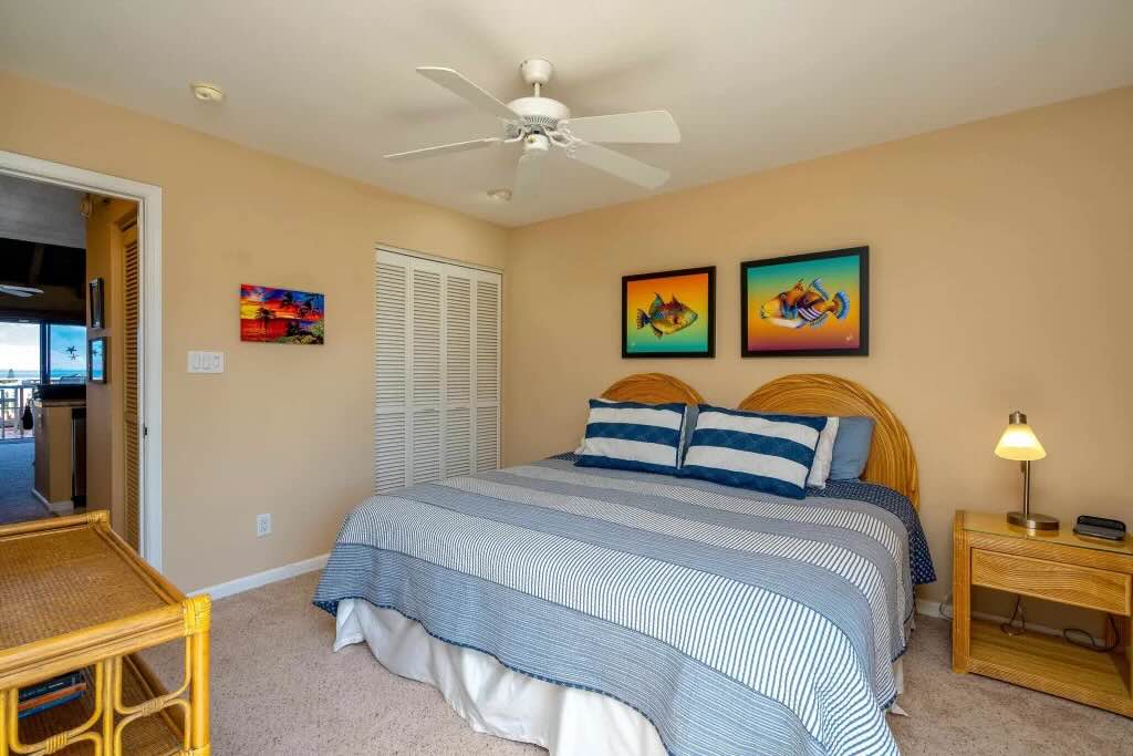 Main-floor bedroom at Maui Kamaole L204 with a new sliding glass door leading to the lanai
